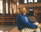 Don Cyr sits inside Notre Dame du Mont-Carmel Church in Lille, 1995. He has made a great effort to restoring this unique church to its original beauty.  Photographer, Paula Lerner,   2003.